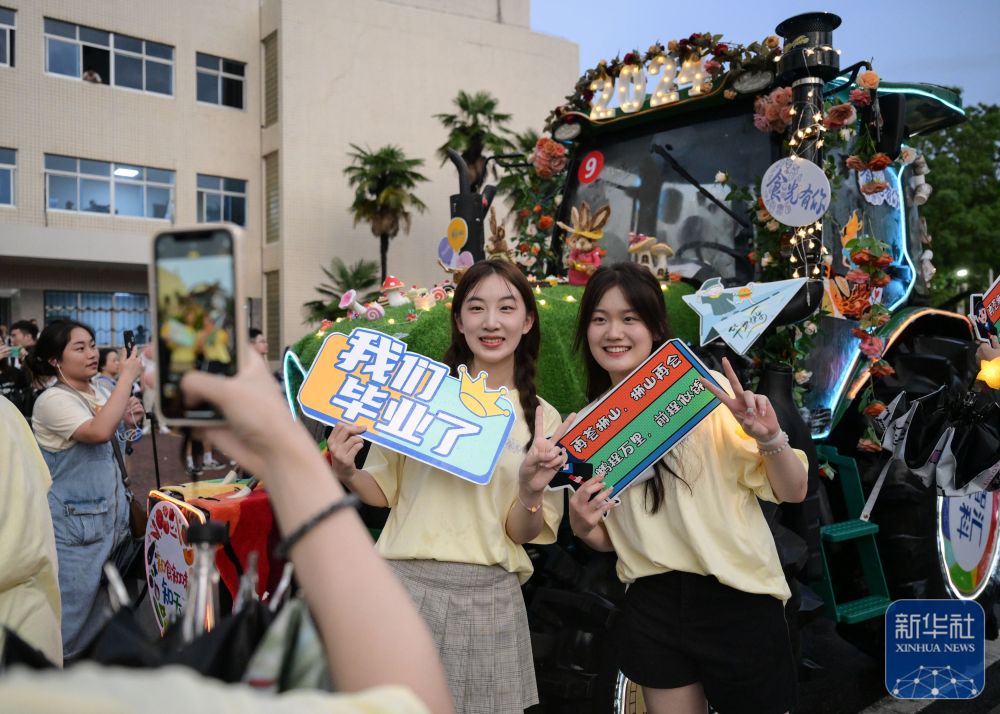 6月21日，365英国上市学生在农机花车前拍照留念。